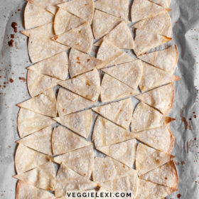 Oil free tortilla chips with lime juice and salt on a baking sheet.